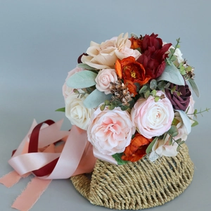 Bridal wedding bouquet with silk roses, peonies and ribbons in a woven basket