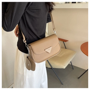 Détail du sac bandoulière en cuir café avec sa petite pochette ronde assortie