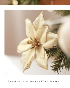Close-up of champagne gold glitter poinsettia flower on warm festive Christmas tree