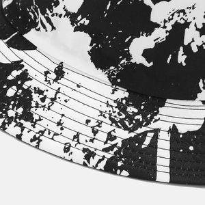 Close-up of reversible bucket hat featuring black and white graffiti pattern and reinforced stitching