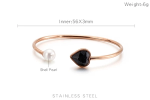 Detail view of rose gold stainless steel cuff featuring black heart stone and shell pearl