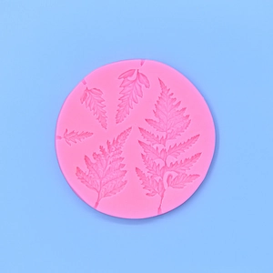 Detailed macro view of a pink silicone mold featuring intricate fern leaf textures