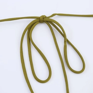 Close-up detail of the olive green silk satin dress featuring a knotted drawstring cord