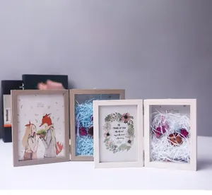 Detail of wooden shadow box frame with dried flowers and raffia DIY display