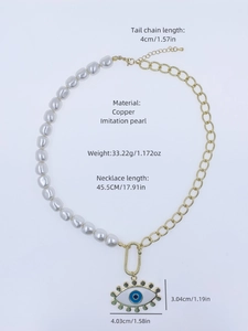 Detail showing white pearl beads with a gold chain and evil eye pendant measurements