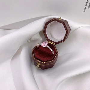 Pink rectangular crystal silver ring displayed in an elegant red velvet octagonal box
