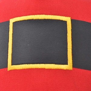 Detail of red Christmas baseball cap showing black belt motif and yellow stitching