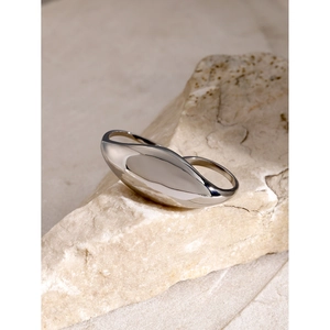 Macro view of polished silver double-finger ring on a natural stone background