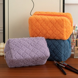 Detailed view of quilted teddy fleece pencil cases in orange, purple and blue tones