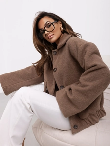 Détail d'une veste en laine marron avec de gros boutons dans un décor de studio