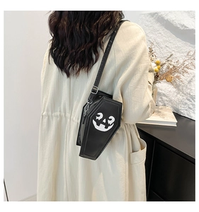 Ghost coffin crossbody bag with pumpkin face print and adjustable shoulder strap worn by model