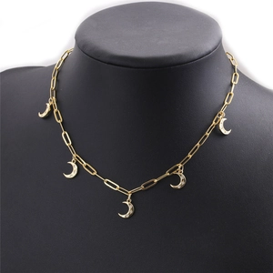 Détail du collier à maillons trombone doré avec pendentifs lune et oxydes de zirconium