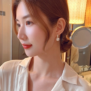 Elegant pearl drop earrings with gold hoop and micro-pave crystals on female model