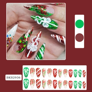 Macro detail of Christmas press-on nails featuring red, green and white festive patterns