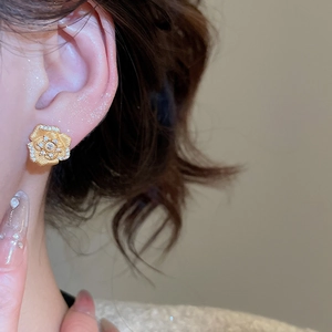 Detailed close-up of a 24K gold-plated floral stud earring with sparkling zircon inlays
