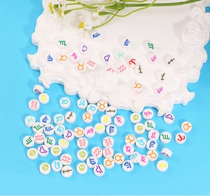 Detaillierte Makroaufnahme weißer Polymerperlen mit bunten Tierkreiszeichen für DIY-Schmuck