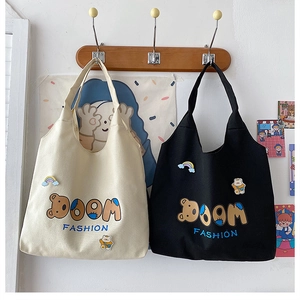Detailansicht der Canvas-Tragetaschen mit Cartoon-Bär-Stickerei und bunten Aufnähern