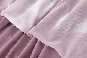 Detailed close-up of pink mesh and knit fabric stitching on a slim fit dress