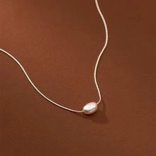 Dettaglio della collana a catena d'argento ondulata con ciondolo in perla naturale lucida