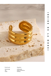 Detailed view of wide gold triple-layered grooved open ring on minimalist stone