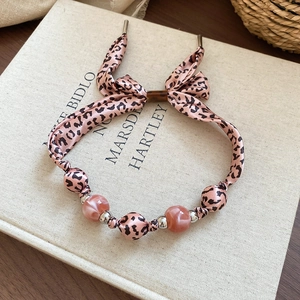Détail du collier fleur en tissu imprimé léopard rose avec perles en résine chic