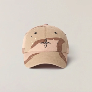 Detail of desert camouflage baseball cap featuring black cross embroidery and metal eyelets