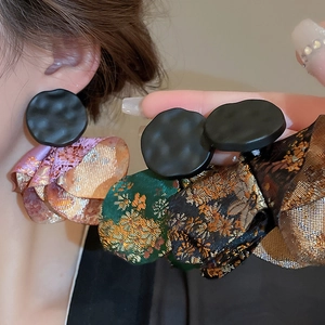 Detailed close-up of embroidered ethnic fan-shaped earrings with metallic stud finish