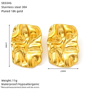 Macro detail of gold-plated geometric wrinkled earrings showing 31x23mm dimensions