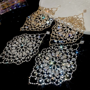 Macro shot of sparkling diamond-encrusted rhombic hollow earrings with long tassels