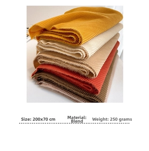 Detail of colorful ribbed knit scarves showing size 200x70cm and blended material texture