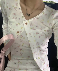 Vue détaillée du cardigan à fleurs montrant la texture tricotée et le bord en dentelle
