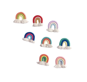 Flat lay of eight colorful handmade woven rainbow keychains with cotton tassels on white