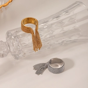 Dettaglio di anelli con perline oro e argento con eleganti nappe a catena lunga