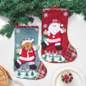 Christmas burlap stockings with Santa and Bear appliques on festive wooden background