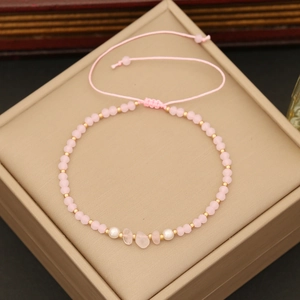 Pink natural stone beaded bracelet with rose quartz and gold spacers on a beige box