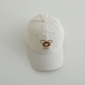 Close-up of a white quick-dry kids cap featuring a brown puppy patch and breathable mesh back