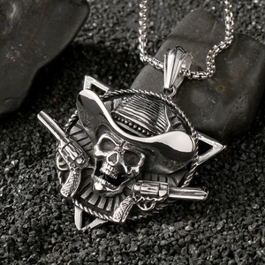 Detailed view of punk silver skull pendant with revolvers on black rocky surface