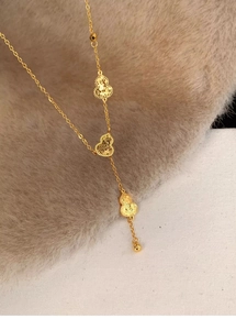 Detail view of 18k gold plated gourd pendants with textured finish on Y-shaped necklace