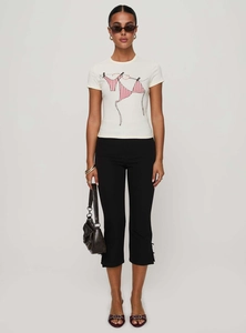 Close-up of women's black cropped flare pants with chic side slits and elastic bow waist