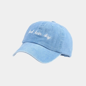 Detail of light blue washed denim baseball cap with white bad hair day embroidery
