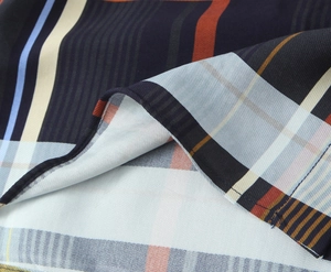 Nahaufnahme der hochwertigen Köper-Karo-Stofftextur in Marineblau und Orangetönen