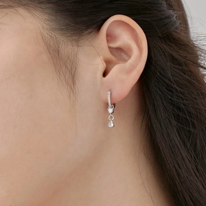 Macro shot of S925 sterling silver drop earring with pear-cut zircon on model ear