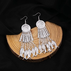 Detailed macro view of vintage silver fish pendants on bohemian ethnic tassel earrings