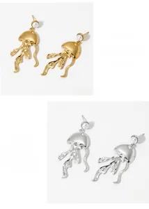 Close-up of jellyfish earrings in gold and silver finish with inlaid white pearls