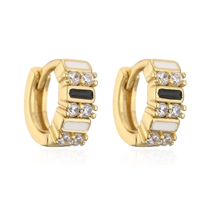 Detailed shot of gold earrings with cubic zirconia and black-white enamel inlay