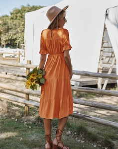 Vue arrière d'une robe midi orange avec jupe à volants, manches bouffantes et lien au cou