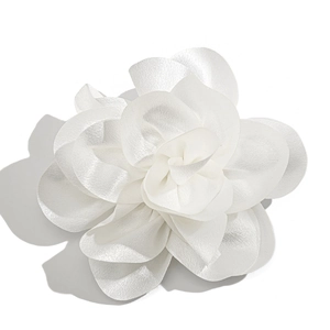 Close-up of a white satin fabric flower showing delicate layered petals and silk texture