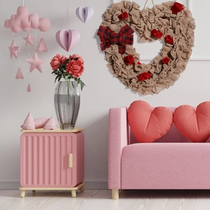 Hanging burlap heart wreath with red roses and plaid bow in a cozy home decor setting