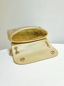 Detail view of the gold rhinestone evening bag showing inner lining and magnetic flap