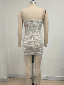 Détail de la mini-robe en dentelle montrant le zip arrière et le design froncé